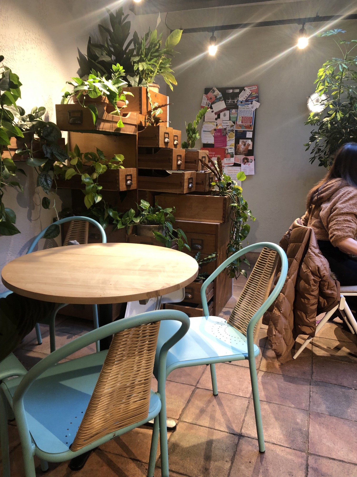 Cramped area between main cafe and toilet with table and chairs blocking paths.