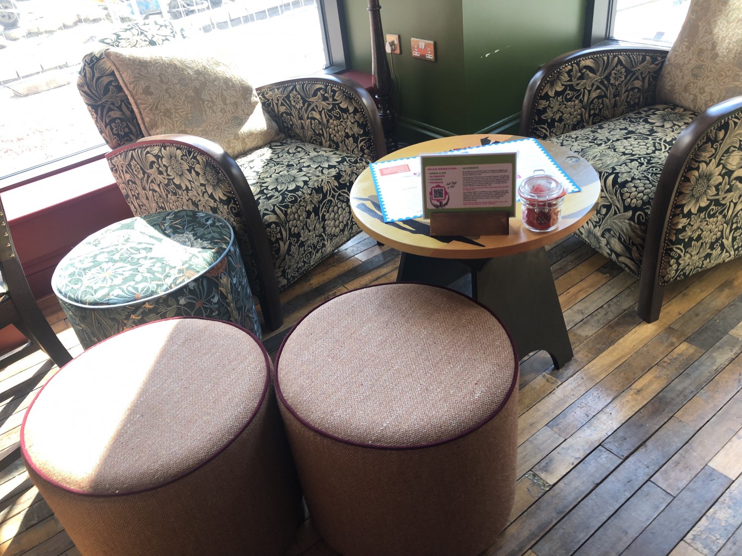 Lounge seating area with low arm chairs and fabric stools and table.