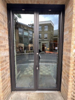 Black framed glass doors. Push from centre to open.