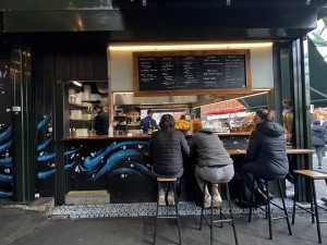 Stall, ordering station right side. Hugh seating left side. Wide pathways around stall.