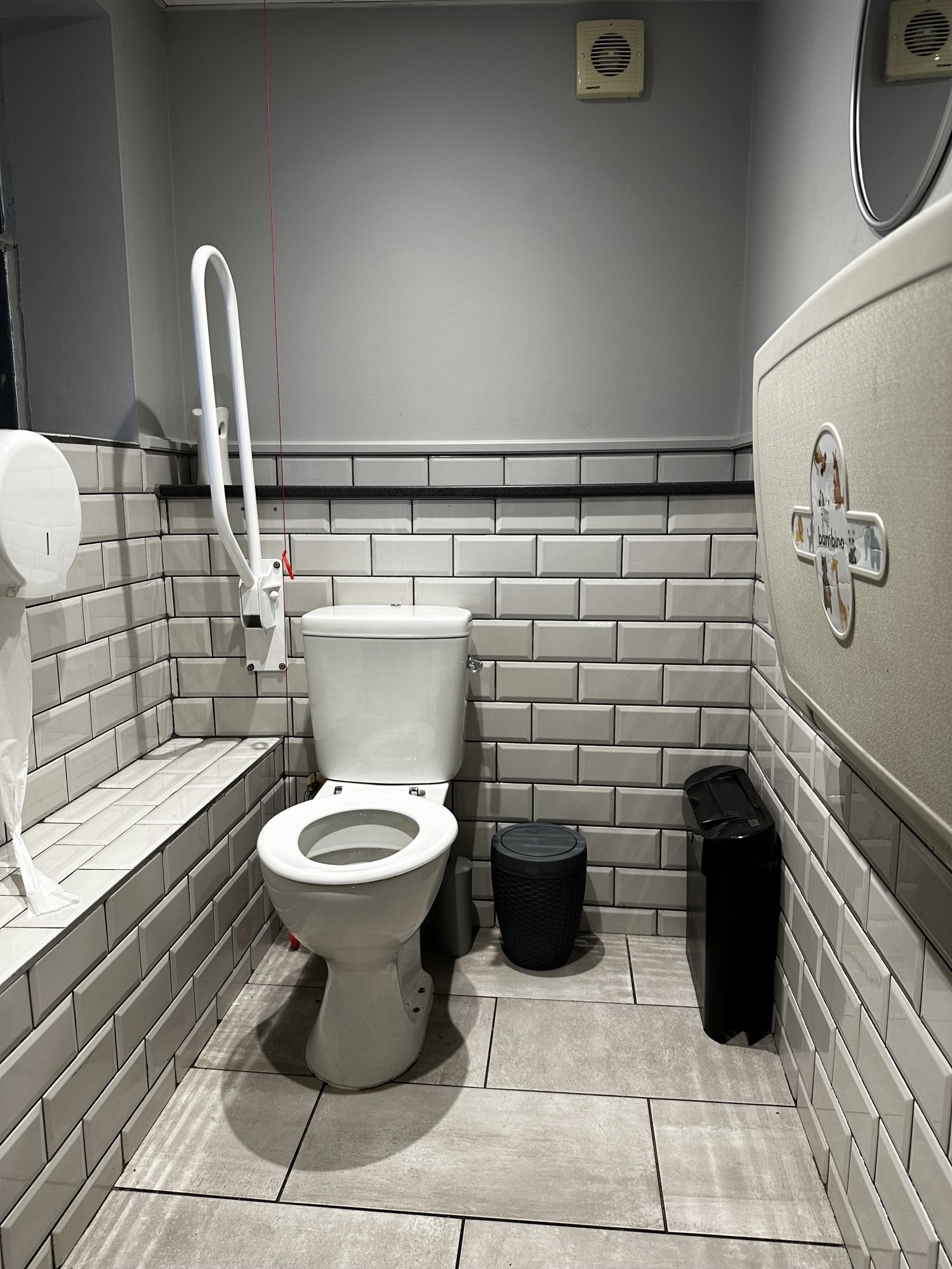 Toilet roll on the left in bathroom roll holder. Baby changing on the right as soon as you enter. Sink on left as soon as you enter. Sanitary bin on left. Toilet  has pull down grab bar next to it on left and bin on right.