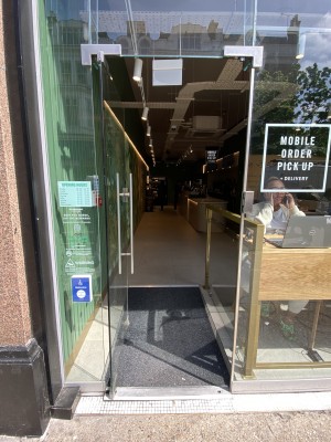 Glass door ahead. Push metal handle on right to open