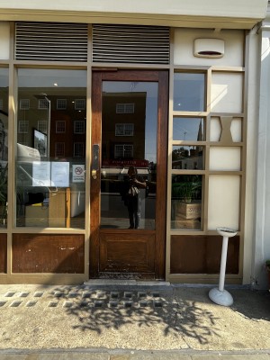 Photo of main entrance door. Very small step at foot of door. Push to open.