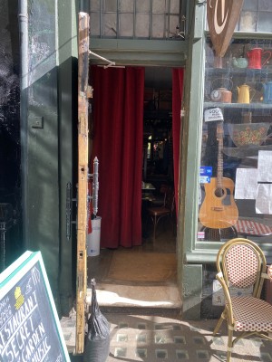 Troubadour door entrance. Black multi-coloured pull door with door handle on right side of door. One step across the door.