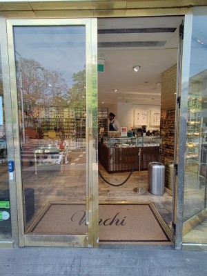 Facing glass doors with brass frame. Push Brass handles in center to open.