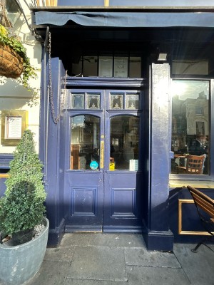 Purple wooden doors ahead with glass panels ahead. Push from centre to open.