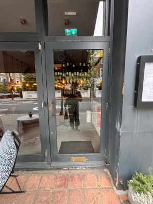 Glass door with grey frames. Pull from left to open.