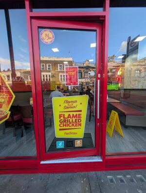 Red frame glass doors in front. Silver handle on right. Push to open.
