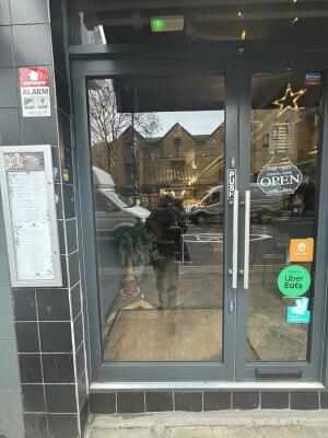 Grey framed glass door ahead. Push from right to open.