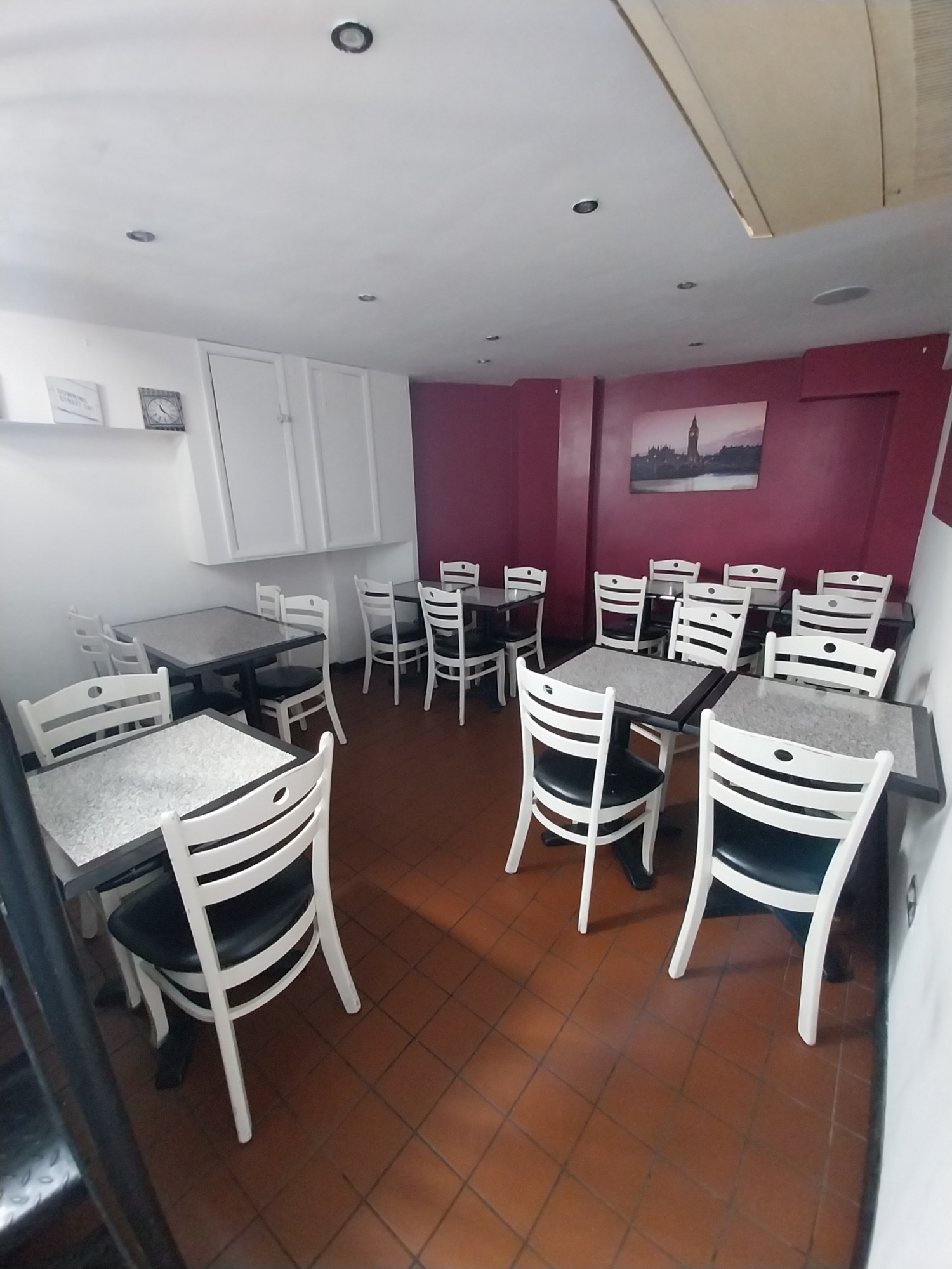 From landing of stairs facing left. Tables with chairs clustered ahead.