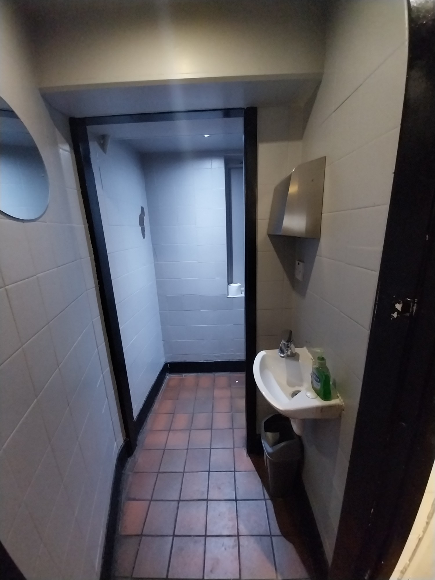 From doorway, looking straight. Sink on right. Archway at back. Path ahead.