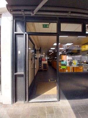 Glass door in black and glass frame. Push metal handle on right to open.