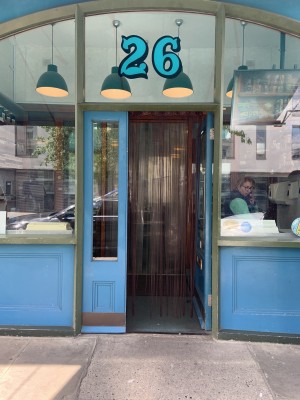 Entrance in centre of venue. Door pushes to open via handle on lefts side. Fixed half door to left of door. String curtains on threshold of door.