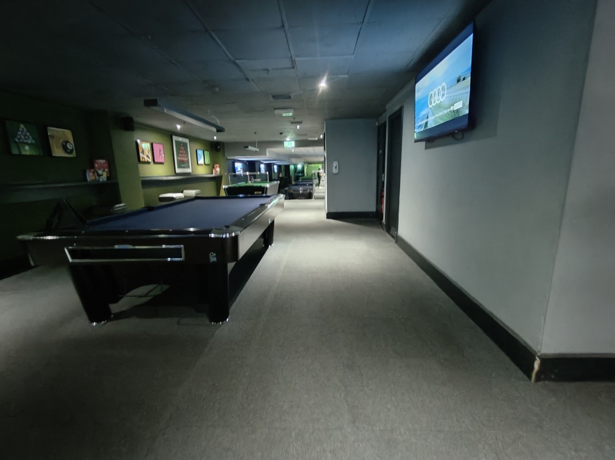From end of stools facing straight. Pool table on left. Path ahead to back area.