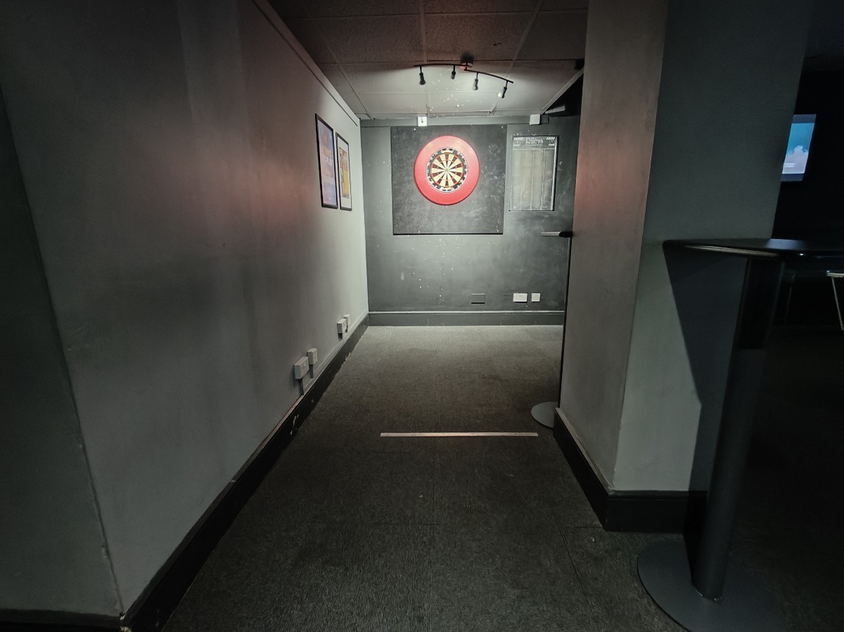From end of stools facing right. Darts station at back.