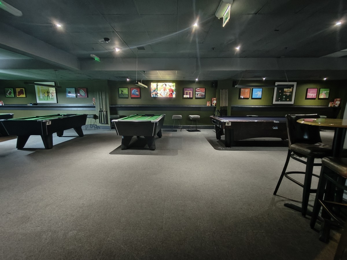 From door facing left. Stools on right. Pool tables along back wall.