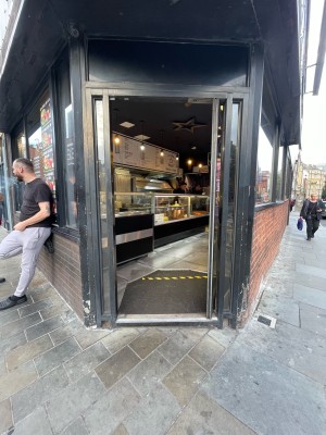 Metal-framed glass door. Push metal handle on left side to open.