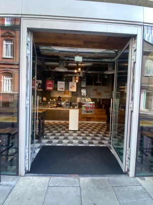 Grey-framed double glass push doors. Handles in middle. Small bump along door.