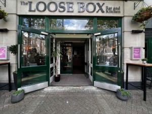 First set of double door. Glass door with dark green wood panelling. Handle in the middle, pull to open.