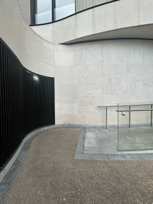From street facing left of venue. Short path ahead to ramp on back right. Glass divider on right.