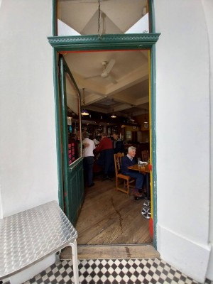 View from street. Manual door push open from right. Seated height table just before doorway on left side.