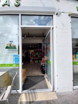 Glass door with white frame. White handle on left, push to open.