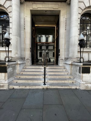 Facing venue. Stairs to first set of double doors divided by handrail in the middle. Double doors after stairs.