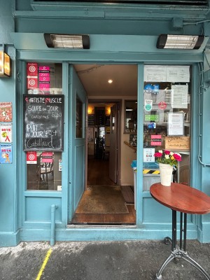 Single light blue wooden door with glass panel. Push small silver vertical handle on right to open.