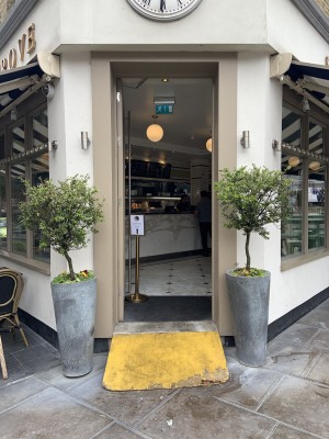 From right corner of venue facing straight. Alternative entrance to take-away area. Push glass door via vertical metal handle on right to open.