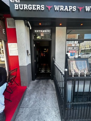 Glass door with black wooden frames. Silver handle on mid right. Push to open