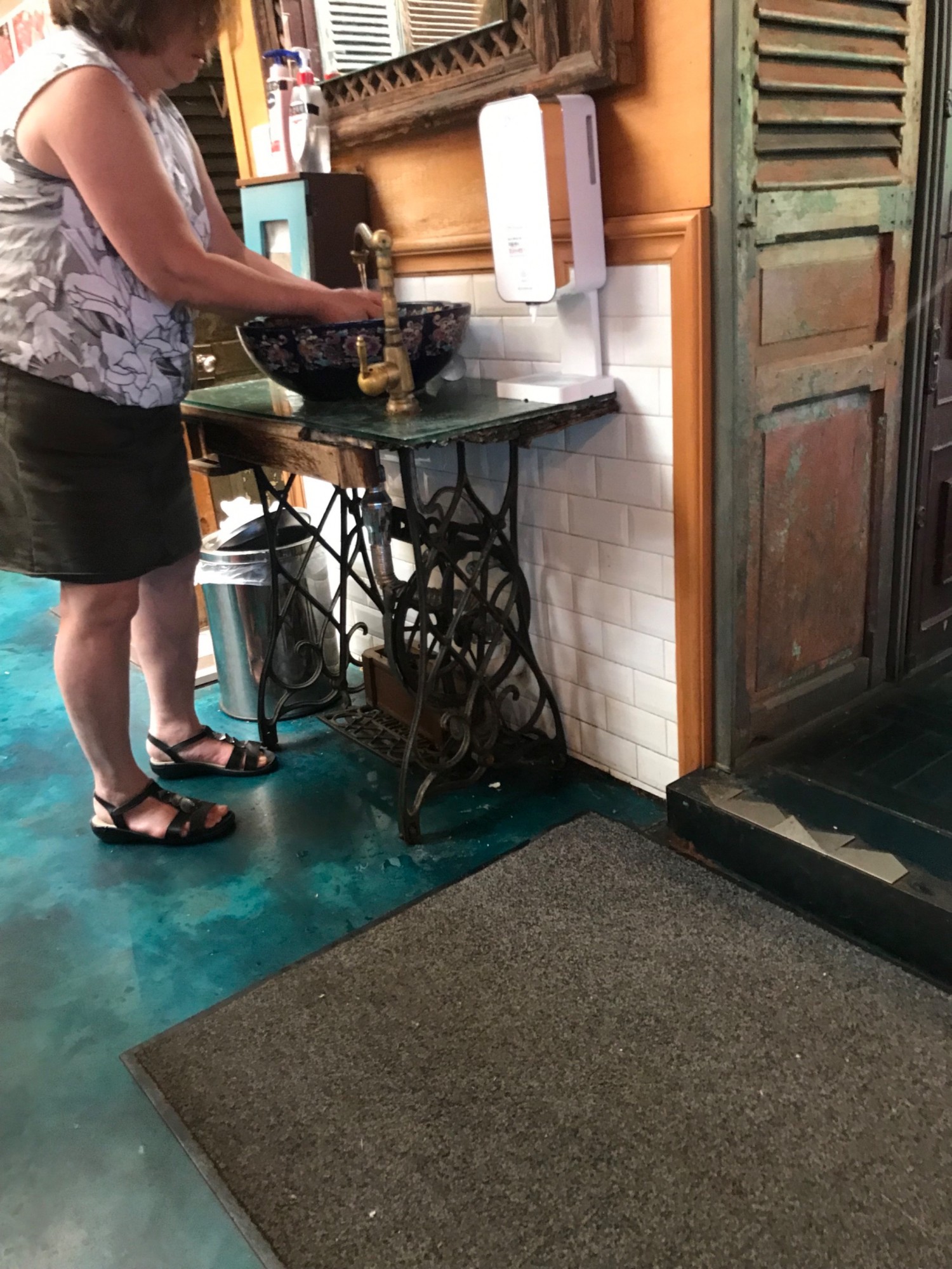 Wash stand is outside of bathroom in the restaurant