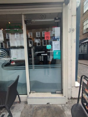 Main entrance. Glass door. Push open to the right, handle on the left. Large step at door.