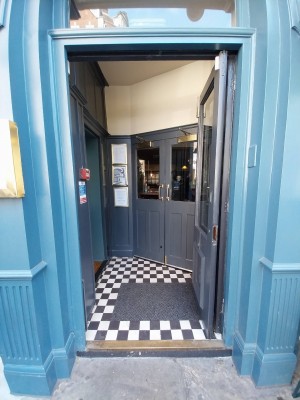 Grey framed glass preceding door. Push from left to open.