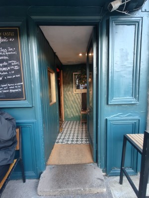 Blue framed glass preceding door. Push from left to open.