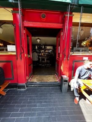 Glass doors with red frame. Golden pad in middle. Push to open.