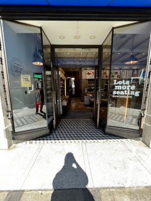 Entrance in centre of venue, dipping back from front wall. Vertical handle on right of door. Pull to open.