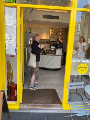 Glass door with yellow, metal frame. Push silver handle on right to open.