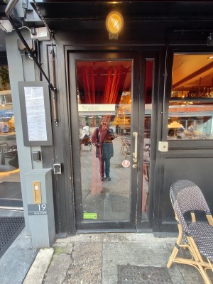 Black framed glass door. Push black handle on right to open.