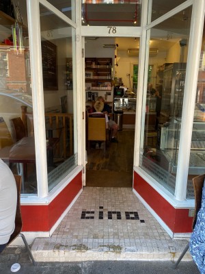 White framed glass push door (handle on right side). One step then flat pathway before you reach door.