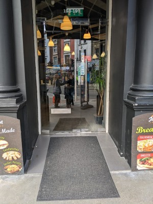 Glass doors with metal frame and metal handles in centre. Pull to open. Slope up before doors.