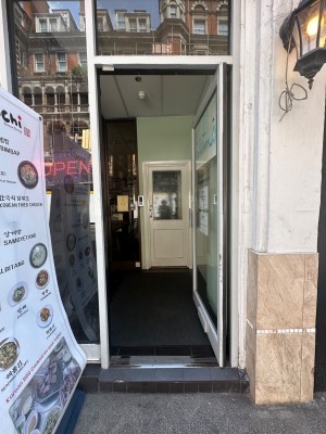 Main entrance. 1 step and after it single glass door straight ahead. Push.