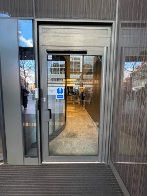 Metal-framed glass door ahead. Pull from grey handle on left to open.