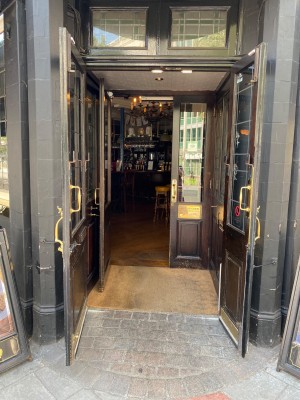 First set of doors of main entrance. Black framed glass pull doors with handles in middle of doors.