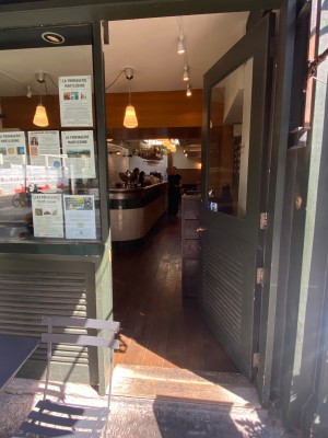 Glass door with black frame. Golden handle on left. Push to open.