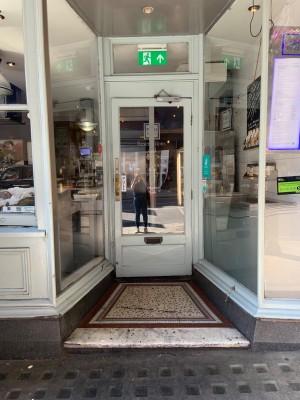 First door to right side of venue dipping back from front window. Door pull to open on left side via small handle.