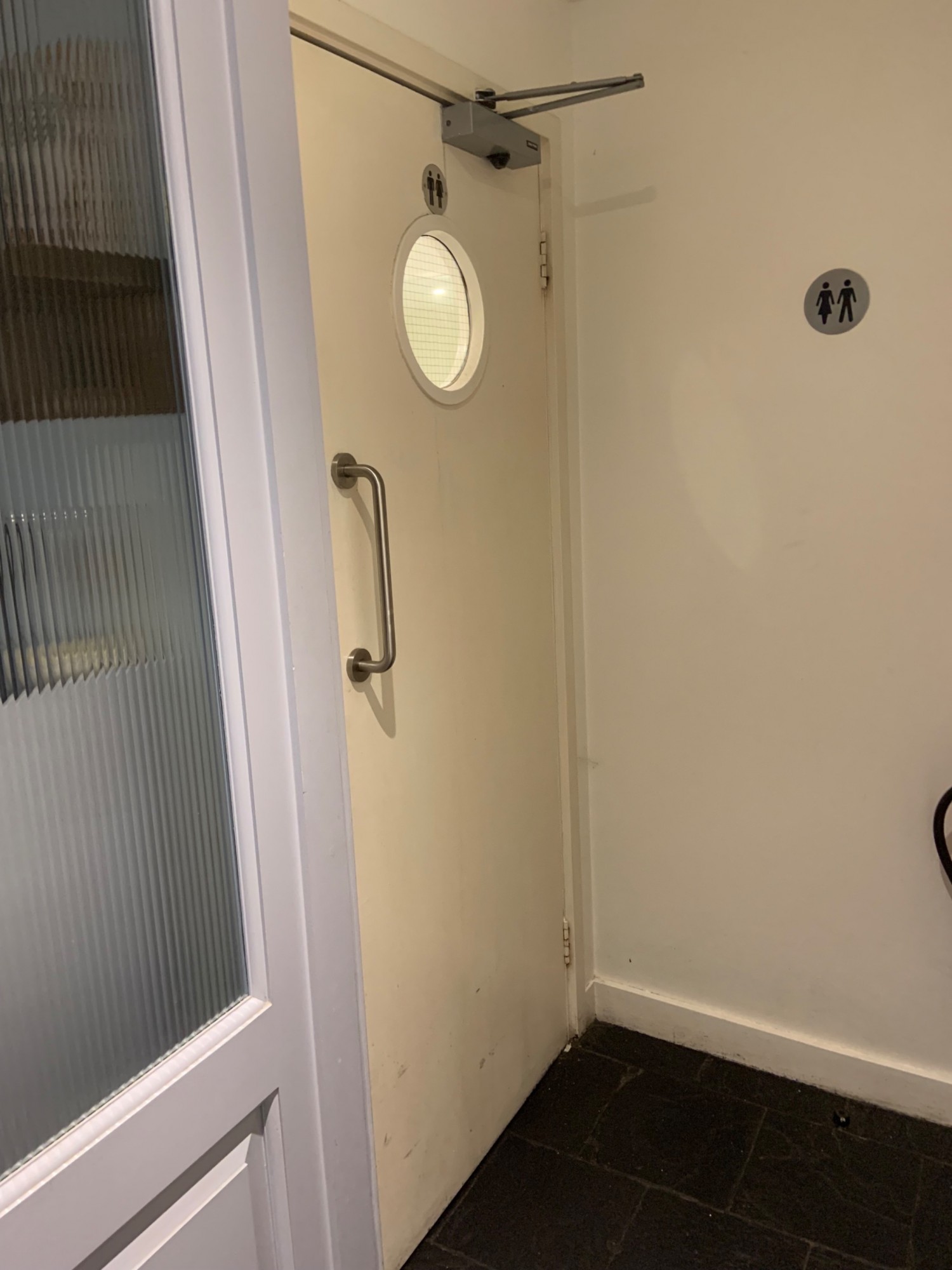 From end of bottom pathway looking at door to bathrooms. Door to pull  to open by high handle on left side.