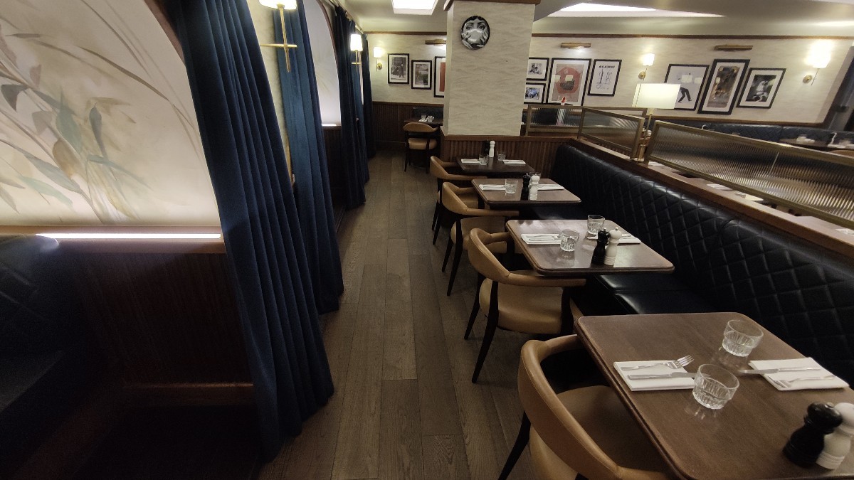 From end of staff counter facing right. Half booths along right. Path in centre. Booths with curtains along left.