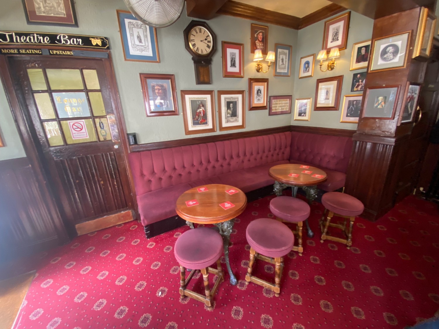 From end of bar, facing right. Half booth along back wall. Stools spread out ahead. Door to upstairs area at back left.