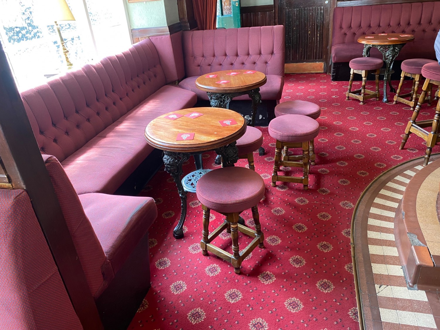 From end of path, facing right. Half booths along left. Path ahead. Path obstructed by stools. Bar on right.