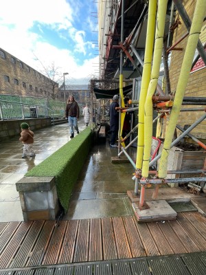 Green bench along left. Path to main entrance ahead. Bench at end of path.